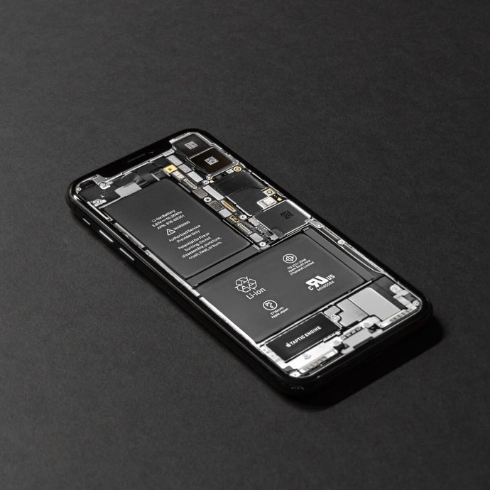 A close-up of an iPhone battery, showcasing the internal components and connectors, with a focus on its compact design and technical details.